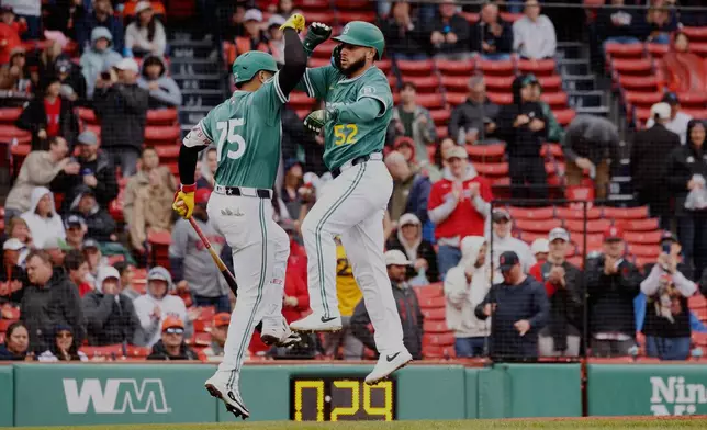Boston Red Sox Wilyer Abreu (52) is congratulated by Carlos Narvaez (75) after hitting a home run during the first inning of the first baseball game of a doubleheader against the Baltimore Orioles, Saturday, May 24, 2025, at Fenway Park in Boston. (AP Photo/Mary Schwalm)