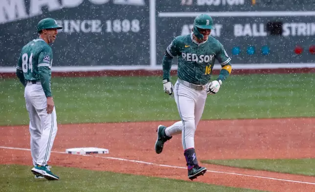 Boston Red Sox's Jarren Duran (16) is congratulated by third base coach Kyle Hudson (84) after hitting a home run off Baltimore Orioles starting pitcher Zach Eflin during the first inning of the first baseball game of a doubleheader, Saturday, May 24, 2025, at Fenway Park in Boston. (AP Photo/Mary Schwalm)