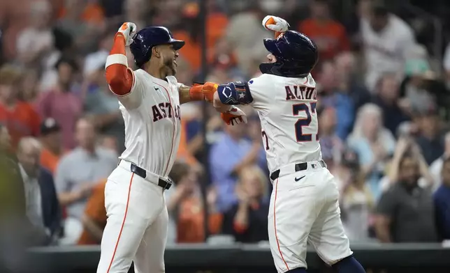 Houston Astros' Jose Altuve (27) celebrates his two-run home run with Jeremy Peña, left, against the Athletics during the fourth inning of a baseball game, Tuesday, May 27, 2025, in Houston. (AP Photo/Karen Warren)