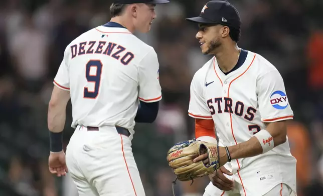 Houston Astros' Zach Dezenzo (9) and Jeremy Peña, right, celebrate the Astros' win over the Athletics during the ninth inning of a baseball game, Tuesday, May 27, 2025, in Houston. (AP Photo/Karen Warren)