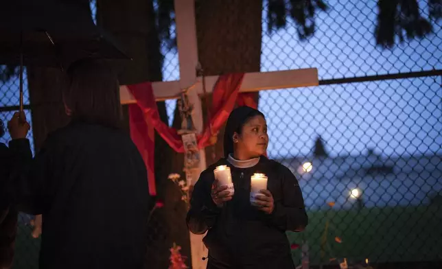 A nun holds candles as people gather for a candlelight march during a vigil on the street where a vehicle-ramming attack occurred at the Filipino community's Lapu Lapu Day festival last week, on a provincial day of mourning for the victims, in Vancouver, on Friday, May 2, 2025. (Darryl Dyck/The Canadian Press via AP)