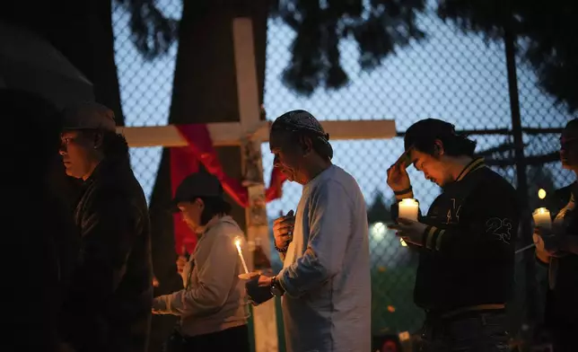 People gather for a candlelight march during a vigil on the street where a vehicle-ramming attack occurred at the Filipino community's Lapu Lapu Day festival last week, on a provincial day of mourning for the victims,, in Vancouver, on Friday, May 2, 2025. (Darryl Dyck/The Canadian Press via AP)