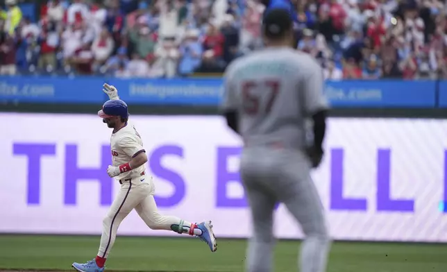 Philadelphia Phillies' Bryce Harper , left, runs the basses after hitting a home run off Arizona Diamondbacks starting pitcher Eduardo Rodriguez (57) during the first inning of a baseball game, Sunday, May 4, 2025, in Philadelphia. (AP Photo/Matt Rourke)