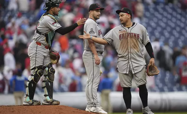 Arizona Diamondbacks' Jose Herrera, left, Jalen Beeks, center, and Josh Naylor, right, celebrate after defeating the Philadelphia Phillies in a baseball game, Sunday, May 4, 2025, in Philadelphia. (AP Photo/Matt Rourke)