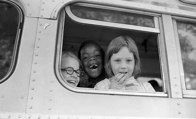 FILE - Children smile from window of a school bus in Springfield, Mass., as court-ordered busing brought Black children and white children together in elementary grades without incident, Sept. 16, 1974. (AP Photo/Peter Bregg, File)
