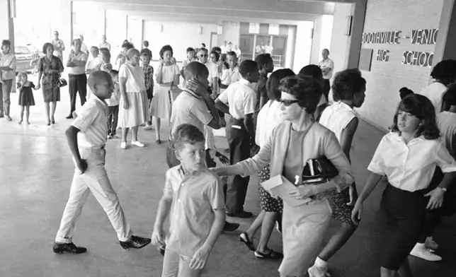 FILE - A white mother walks with her son past a group of African American students arriving for classes at formerly all-white Boothville Venice High School on Monday, Sept. 12, 1966 as racial barriers fell in Plaquemines Parish. (AP Photo/Jack Thornell, file)