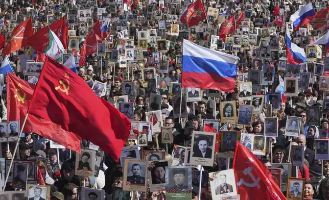 People carry portraits of relatives who fought in World War II, during the Immortal Regiment march at the Nevsky prospect, the central avenue of St. Petersburg, Russia, Friday, May 9, 2025, during celebrations of the 80th anniversary of the Soviet Union's victory over Nazi Germany during the World War II. (AP Photo/Dmitri Lovetsky)