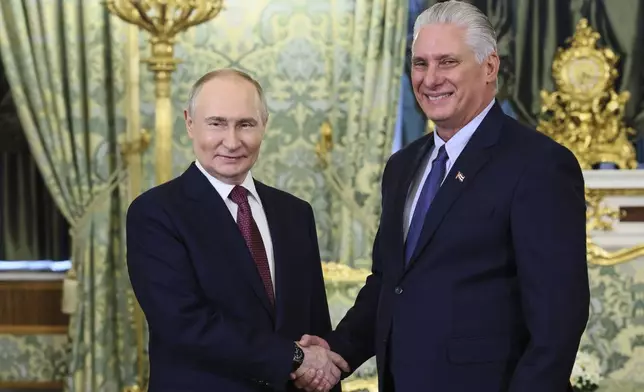 Russian President Vladimir Putin and Cuban President Miguel Diaz-Canel shake hands during a meeting at the Kremlin in Moscow, Russia, Wednesday, May 7, 2025, ahead of celebrations of the 80th anniversary of the Soviet Union's victory over Nazi Germany during the World War II. (Mikhail Metzel, Sputnik, Kremlin Pool Photo via AP)
