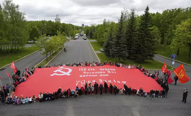 Russian Communist's Party supporters unfurl a giant replica of the Soviet Flag of Victory marking the upcoming Victory Day to celebrate 80 years after the victory in World War II, The Great Patriotic War for the Soviet Union, in Moscow, Russia, Thursday, May 8, 2025. (AP Photo/Alexander Zemlianichenko)