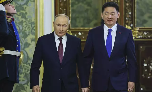 Russian President Vladimir Putin, centre, and Mongolian President Ukhnaagiin Khurelsukh arrive for their talks at the Kremlin in Moscow, Russia, Wednesday, May 7, 2025. (Yuri Kochetkov/Pool Photo via AP)