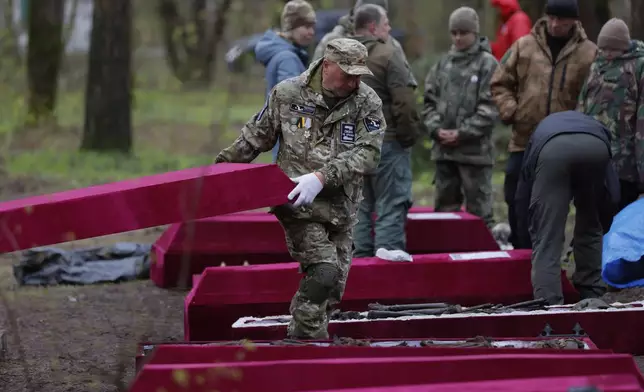 Members of volunteer search teams prepare coffins with the remains of Soviet soldiers killed during World War II for a reburial ceremony at the Sinyavino Heights memorial near the village of Sinyavino, 50 km (31 miles) east of St. Petersburg, Russia, Wednesday, May 7, 2025, ahead of celebrations of the 80th anniversary of the Soviet Union's victory over Nazi Germany during the World War II. (AP Photo/Elena Ignatyeva)