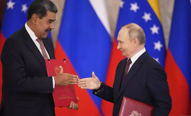 Russian President Vladimir Putin, right, and Venezuelan President Nicolas Maduro exchange documents during a signing ceremony following their talks at the Kremlin in Moscow, Russia, Wednesday, May 7, 2025, ahead of celebrations of the 80th anniversary of the Soviet Union's victory over Nazi Germany during the World War II. (AP Photo/Alexander Zemlianichenko)