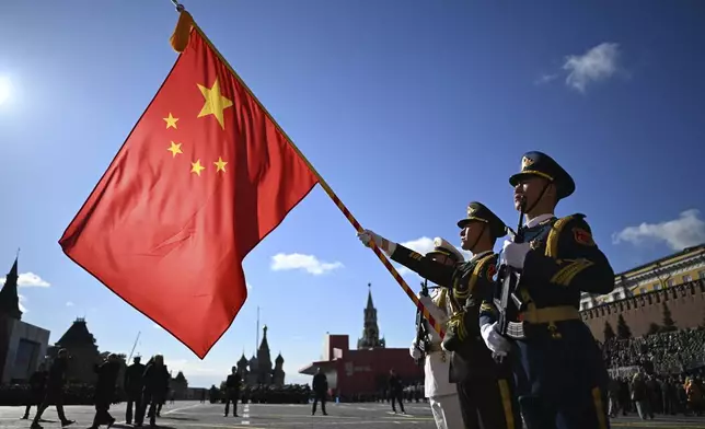 Chinese servicemen hold their national flag as they attend the Victory Day military parade in Moscow, Russia, Friday, May 9, 2025, during celebrations of the 80th anniversary of the Soviet Union's victory over Nazi Germany during the World War II. (Pelagia Tikhonova/Photo host agency RIA Novosti via AP)