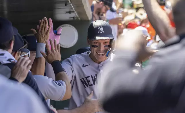 New York Yankees' Aaron Judge, center, celebrates in the dugout after hitting a solo home run during the fourth inning of a baseball game against the Athletics, Saturday, May 10, 2025, in West Sacramento, Calif. (AP Photo/Sara Nevis)