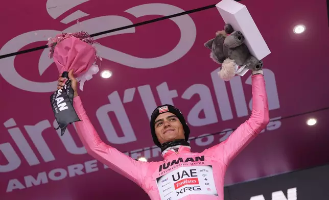 Mexico's Isaac Del Toro wears the pink jersey of the race overall leader as he celebrates on the podium after winning the 14th stage of the Giro d'Italia cycling race from Treviso to Nova Gorica/Gorizia, Italy, Saturday, May 24, 2025. (Fabio Ferrari/LaPresse via AP)