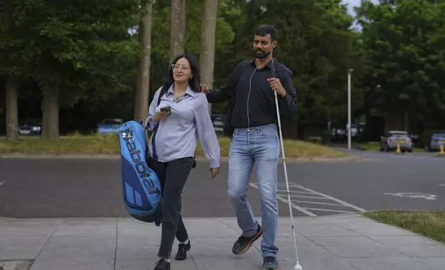 Blind tennis champion Naqi Rizvi and his wife Zara attend a visually impaired tennis training session in London, Tuesday, May 20, 2025. (AP Photo/Kin Cheung)