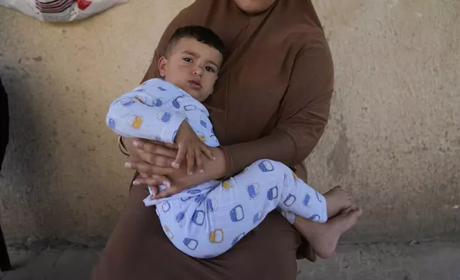 Palestinian Hazar Estity holds her 21-month-old son, Nizar, on April 29, 2025, in the West Bank town of Zababdeh, where they fled when the Jenin refugee camp was raided by the Israeli army. Estity says she was used as a human shield by Israeli soldiers there. (AP Photo/Nasser Nasser)