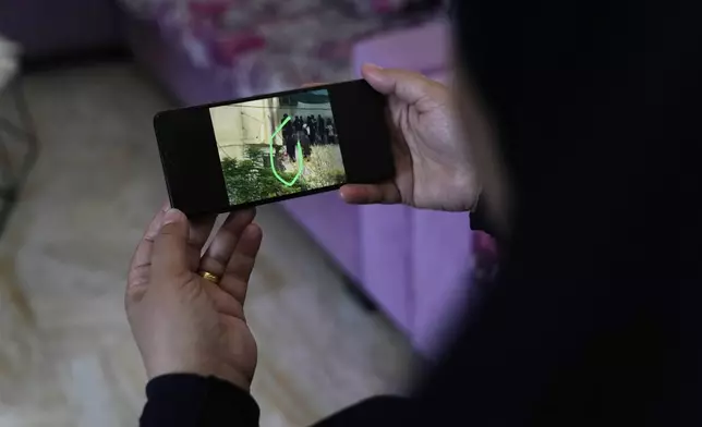 On April 29, 2025, at her apartment in the occupied West Bank town of Zababdeh, Palestinian Iman Amer pulls up a photo that she says shows Israeli soldiers forcing her to go to a neighbor's house as a human shield in the Jenin refugee camp. (AP Photo/Nasser Nasser)