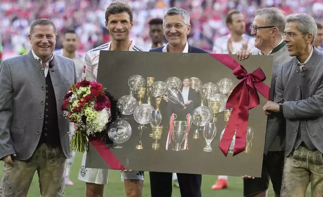 Bayern's Thomas Mueller, second left, poses with club president Herbert Hainer, centre, and other club officials during a farewell ahead of his last home game for Bayern Munich at the German Bundesliga soccer match between FC Bayern Munich and Borussia Moenchengladbach in Munich, Germany, Saturday, May 10, 2025. (AP Photo/Matthias Schrader)