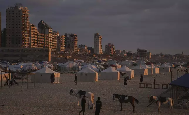 Displaced Palestinians walk along a makeshift tent camp at the shore of Gaza City on Thursday, May 22, 2025. (AP Photo/Jehad Alshrafi)
