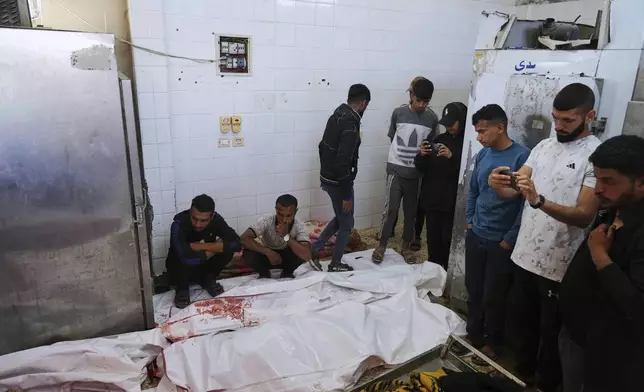 Palestinian mourn their relatives who were killed in an Israeli army airstrike on the Gaza Strip, at the morgue of Al-Aqsa Hospital in Deir al-Balah, Gaza, Thursday, May 22, 2025. (AP Photo/Abdel Kareem Hana)