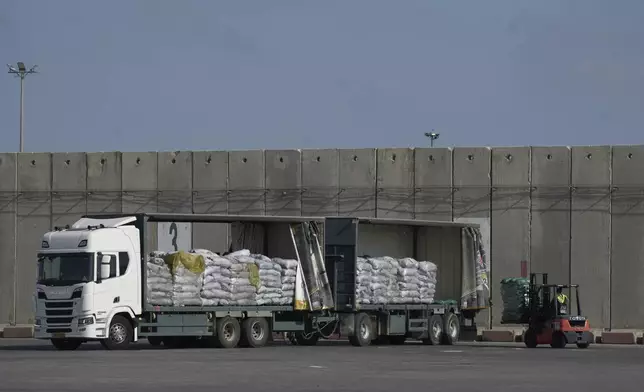 A worker unloads cargo from a truck carrying humanitarian aid for the Gaza Strip at the offload area of the Kerem Shalom border crossing between Israel and Gaza, southern Israel, Thursday, May 22, 2025. (AP Photo/Leo Correa)