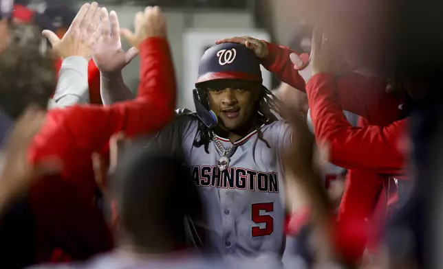 Washington Nationals' CJ Abrams celebrates after scoring off a single hit by Nathaniel Lowe during the 10th inning of a baseball game against the Seattle Mariners Thursday, May 29, 2025, in Seattle. (AP Photo/Ryan Sun)