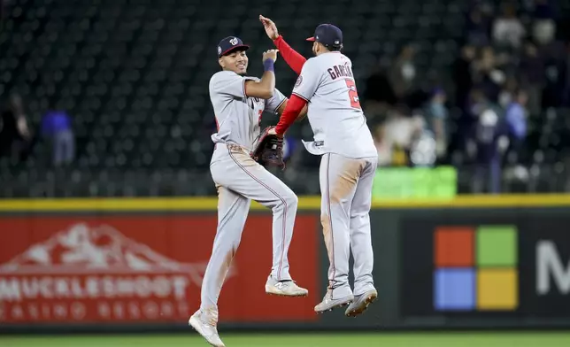 Washington Nationals second baseman Luis Garcia Jr., right, and left fielder James Wood celebrate after the team's win in a baseball game against the Seattle Mariners Thursday, May 29, 2025, in Seattle. (AP Photo/Ryan Sun)