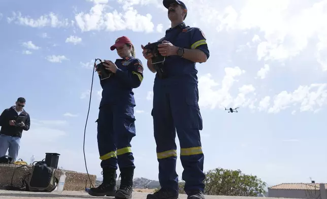 Firefighters fly a drone during the "Through Fire 2025" drill in Lavrio, about 60 kilometres (37 miles) southeast of Athens, Greece, Thursday, May 22, 2025. (AP Photo/Thanassis Stavrakis)