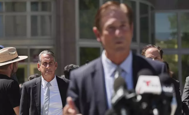 Bryan Freedman, an attorney representing family members of Erik and Lyle Menendez, left, looks on as Los Angeles County District Attorney Nathan Hochman speaks outside of the courthouse Friday, May 9, 2025, in Los Angeles. (AP Photo/Jae C. Hong)