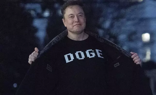FILE - Elon Musk flashes his T-shirt that reads "DOGE" to the media as he walks on the South Lawn of the White House, in Washington, March 9, 2025. (AP Photo/Jose Luis Magana, File)