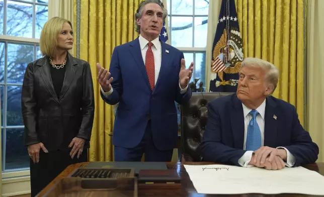 FILE - Interior Secretary Doug Burgum speaks as his wife, Kathryn, and President Donald Trump listen, in the Oval Office of the White House, Friday, Jan. 31, 2025, in Washington. (AP Photo/Evan Vucci,File)