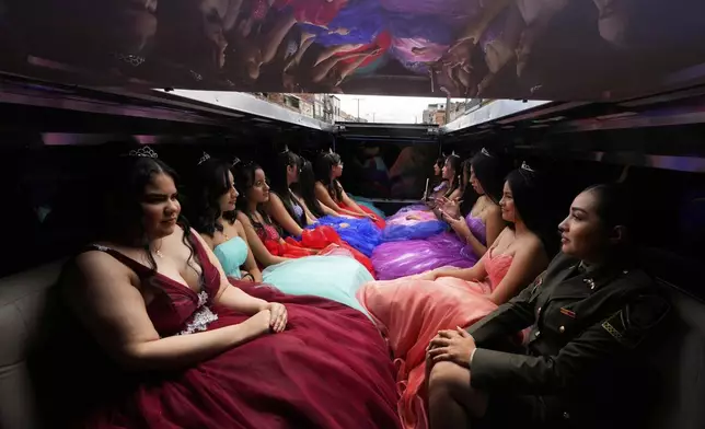 Quinceañeras ride in limousine as part of their celebration, in Bogota, Colombia, Friday, May 2, 2025. The Sueños Hechos Foundation, led by a former police officer, is hosting a quinceañera celebration on Friday for 24 disadvantaged teen girls. (AP Photo/Fernando Vergara)