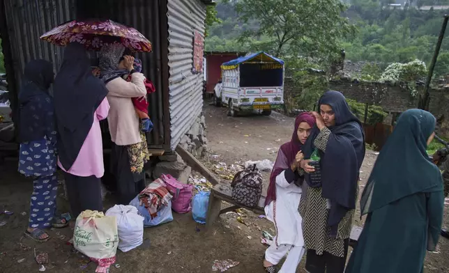 A group of Kashmiri villager women wait for transportation as they leave following overnight shelling from Pakistan at Gingal village in Uri district, Indian controlled Kashmir, Friday, May 9, 2025. (AP Photo/Dar Yasin)
