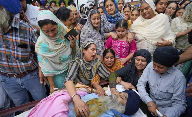 Relatives mourn near the body of Amarjeet Singh, 51, killed in Pakistani artillery shelling in in Poonch along the Line of Control, Indian controlled Kashmir, Thursday, May 8, 2025. (AP Photo/Channi Anand)
