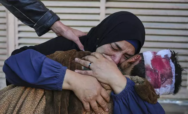 Palestinian Maha Elayan weeps as she embraces the body of her 7-year-old son, Qasim, who was killed in an overnight Israeli airstrike on a UN school used as a shelter, ahead of his burial at Al-Aqsa Hospital in Deir al-Balah, in the central Gaza Strip, Wednesday, May 7, 2025. (AP Photo/Abdel Kareem Hana)