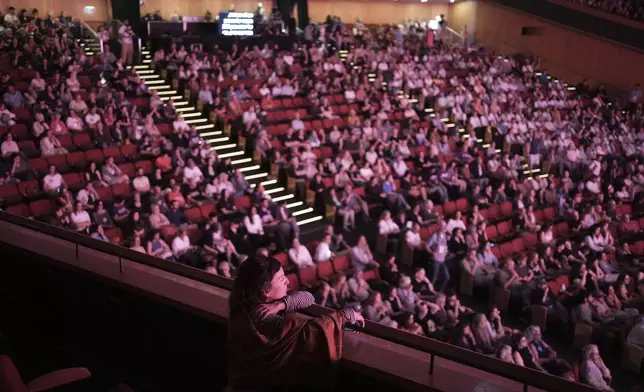 A woman watches the opening session of the People's Peace Summit in Jerusalem, Friday, May 9, 2025. (AP Photo/Maya Alleruzzo)