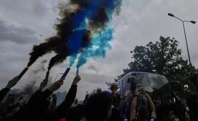 Inter Milan fans let off flares as a bus carrying Inter Milan players arrives ahead of the Champions League semifinal second leg soccer match between Inter Milan and Barcelona at San Siro stadium in Milan , Italy, Tuesday, May 6, 2025. (AP Photo/Luca Bruno)