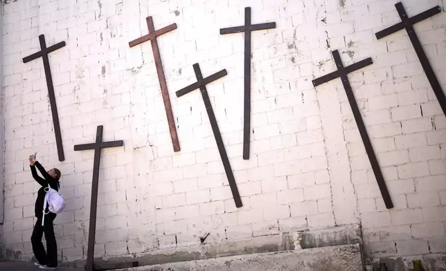A woman, who only gave her first name as Ana, takes a picture as she visits a parish named after the Peruvian saint, Santo Tomas de Porres, the day Cardinal Robert Prevost was announced as Pope Leo XIV, Thursday, May 8, 2025, in Tijuana, Mexico. (AP Photo/Gregory Bull)