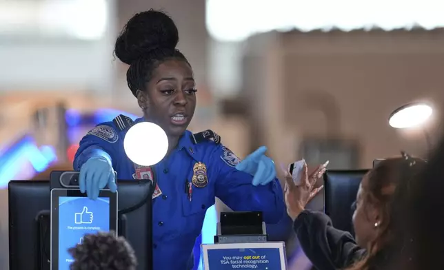A TSA employee checks IDs as people move through security at Newark Liberty International Airport in Newark, N.J., Wednesday, May 7, 2025. (AP Photo/Seth Wenig)