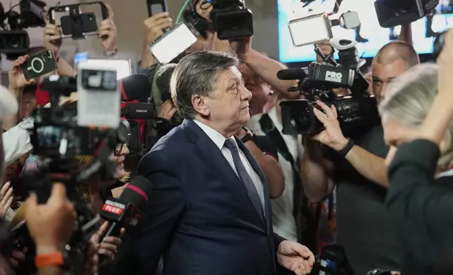 Presidential candidate Crin Antonescu walks surrounded by media shortly before polls closing during the first round of the country's presidential election redo in Bucharest, Romania, Sunday, May 4, 2025. (AP Photo/Vadim Ghirda)