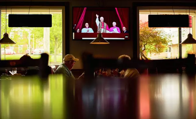 Patrons watch live coverage of the newly elected Pope Leo XIV from St. Peter's Basilica at the Vatican while having lunch at Ron's Roost Chicken Restaurant, Thursday, May 8, 2025, in Cincinnati. (AP Photo/Carolyn Kaster)