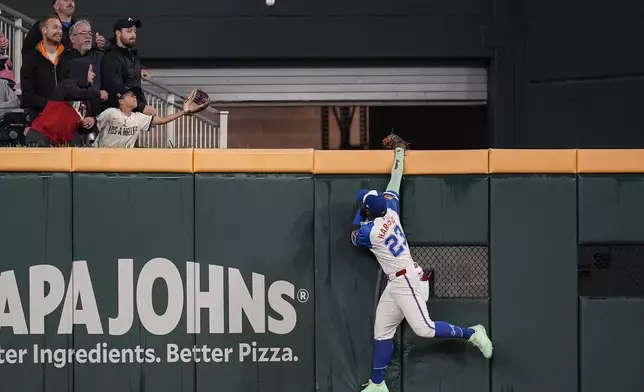 Atlanta Braves outfielder Michael Harris II (23) tries to catch the ball of the bat of Los Angeles Dodgers two-way player Shohei Ohtani (17) in the third inning of a baseball game, Saturday, May 3, 2025, in Atlanta. (AP Photo/Mike Stewart)