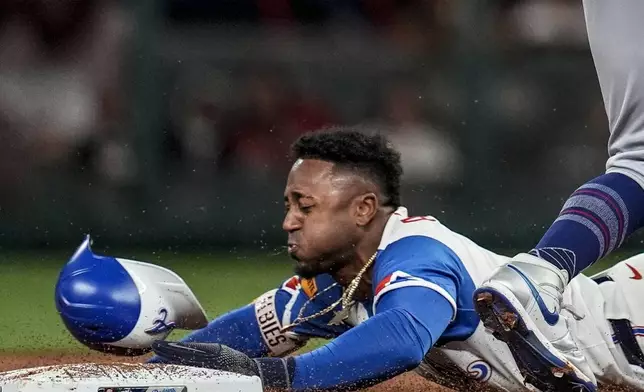 Atlanta Braves' Ozzie Albies (1) steals second base against Los Angeles Dodgers shortstop Mookie Betts (50) in the second inning of a baseball game, Saturday, May 3, 2025, in Atlanta. (AP Photo/Mike Stewart)