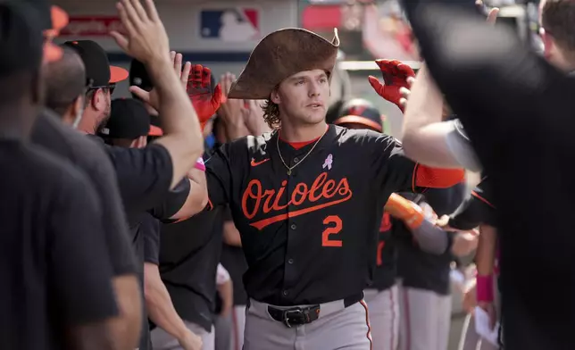 Baltimore Orioles' Gunnar Henderson (2) high-fives teammates in the dugout after hitting a home run during the sixth inning of a baseball game against the Los Angeles Angels, Sunday, May 11, 2025, in Anaheim, Calif. (AP Photo/Eric Thayer)