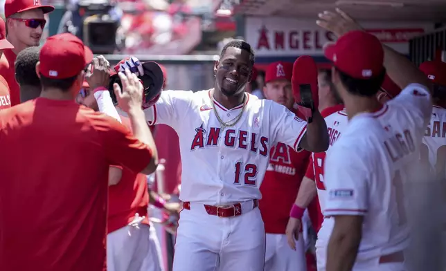 Los Angeles Angels' Jorge Soler (12) high fives teammates after scoring during the first inning of a baseball game against the Baltimore Orioles, Sunday, May 11, 2025, in Anaheim, Calif. (AP Photo/Eric Thayer)