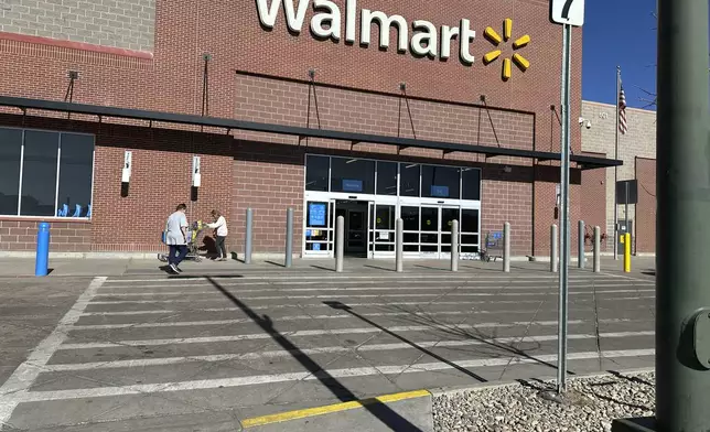 FILE -Shoppers outside a Walmart store, Feb. 7, 2025, in Englewood, Colo. (AP Photo/David Zalubowski), File)