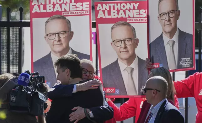 Australian Prime Minister Anthony Albanese embraces his son Nathan as he arrives at a polling booth to vote in his electorate in Sydney, Saturday, May 3, 2025. (AP Photo/Rick Rycroft)