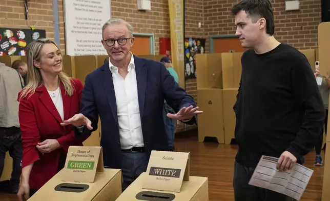 Australian Prime Minister Anthony Albanese, center, and his son Nathan react after voting as Albanese's partner Jodie Haydon watches at a polling booth in his electorate in Sydney, Saturday, May 3, 2025. (AP Photo/Rick Rycroft)