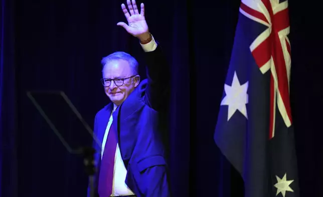 Australian Prime Minister Anthony Albanese waves as he prepares to address the party faithful after winning a second term following the general election in Sydney, Saturday, May 3, 2025. (AP Photo/Rick Rycroft)